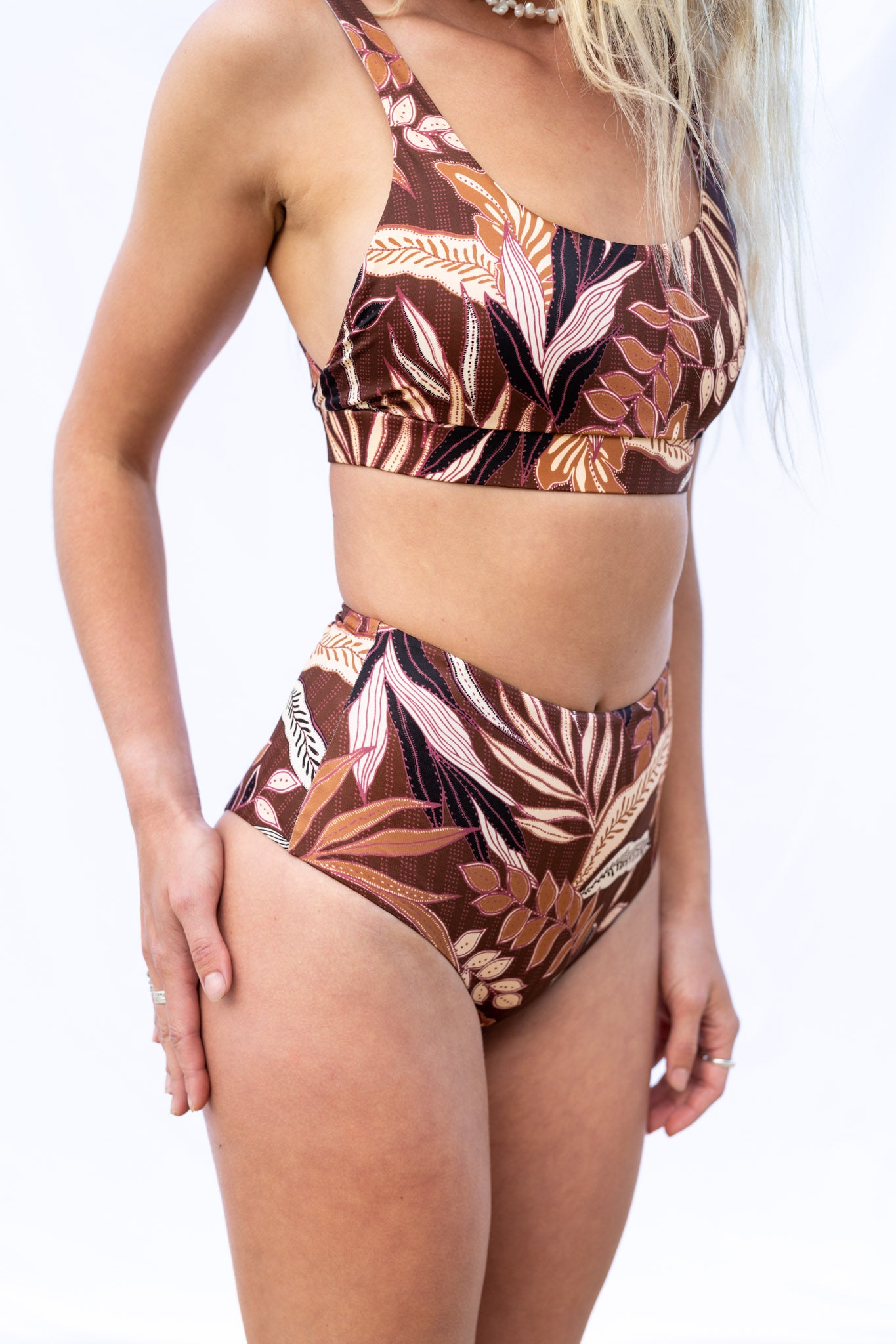 Closeup of the Elation Boa surf bottoms and Elation Coco surf top, with the model slightly facing away from the camera